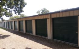 Row of green roll-up storage unit doors